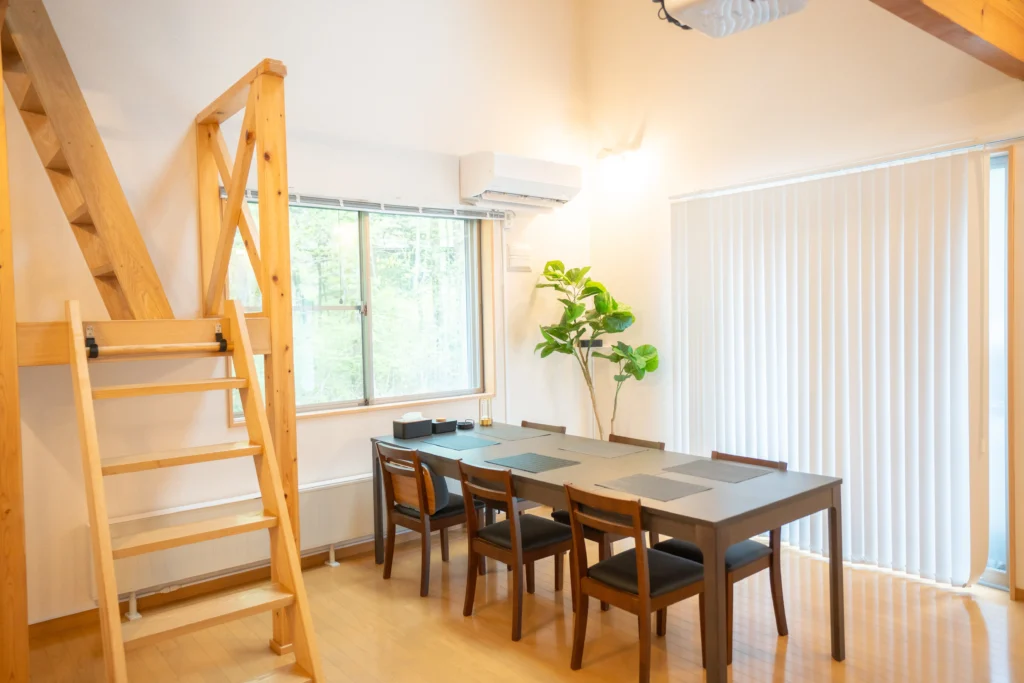 Dining table and loft stairs inside Kinfolk Yamanakako