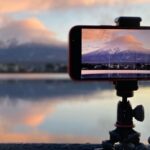 A smartphone recording Mount Fuji beside Lake Kawaguchiko