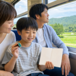 A child holding a blank stamp booklet while riding a local train with family