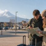 Travelers checking their route outside Kawaguchiko Station with Mt. Fuji in the distance