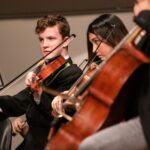 Young string musicians performing indoors for the Kawaguchiko Music Forest concert update
