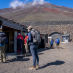 Prepared hikers checking a mountain support station on Mt. Fuji for a 2026 first-aid facilities update