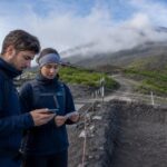 Travelers checking Mt. Fuji Yoshida Trail access information near a trail entrance