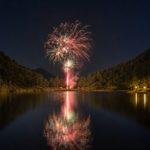 Fireworks reflecting across a quiet forested mountain lake at night