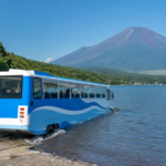 Unbranded amphibious sightseeing bus entering Lake Yamanaka below snow-free Mount Fuji