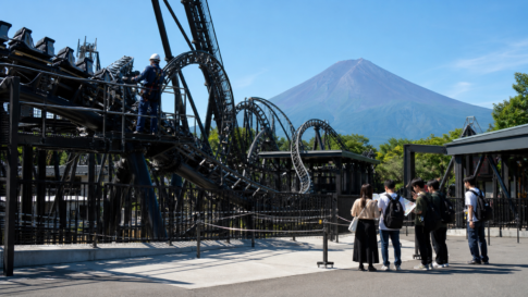 Text-free view of a roller coaster inspection at a Fuji foothills amusement park with bare Mount Fuji beyond