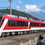 Text-free red-and-white local train presented to photographers at a Fuji-area railway depot