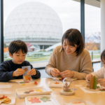 Text-free family making autumn crafts in a museum lobby with a white radar dome outside