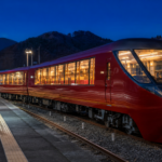 Text-free deep-red panoramic train photographed safely at a mountain railway platform after sunset