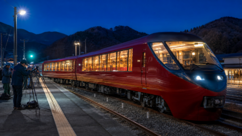 Text-free deep-red panoramic train photographed safely at a mountain railway platform after sunset