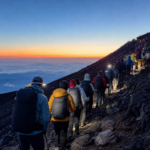 Properly equipped hikers moving in an orderly line on Mt. Fuji before sunrise