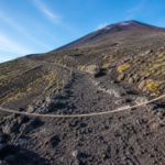 A rope barrier across an empty volcanic hiking trail on snow-free Mount Fuji