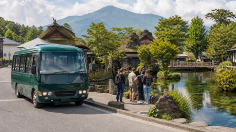 A plain green local bus beside clear spring ponds and traditional wooden buildings in a summer village