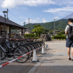 Travelers checking alternatives beside unavailable rental bicycles near a station in the Fuji Five Lakes