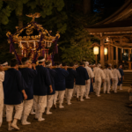 A mikoshi procession in plain festival clothing entering a traditional Japanese shrine at night