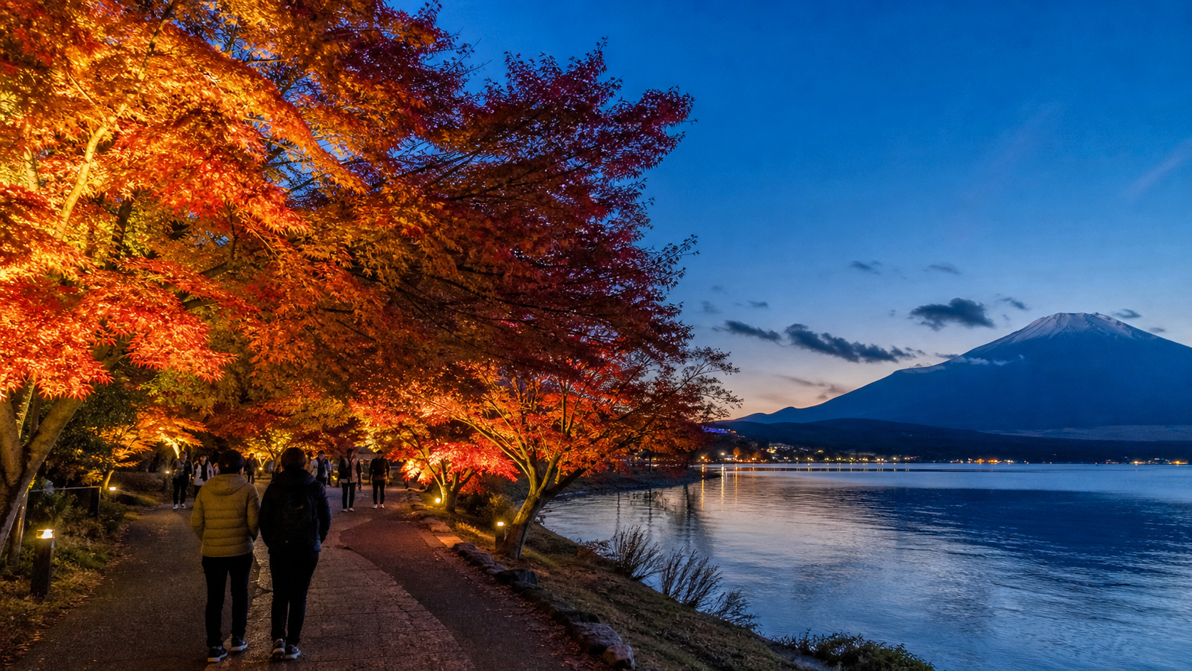 Text-free illuminated autumn maple path beside Lake Yamanaka with Mount Fuji at blue hour