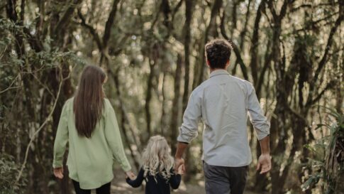 A family walking together on a shaded forest path