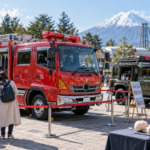 Families viewing a fire engine and emergency response vehicle at an amusement park safety event