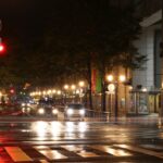 Cars with headlights approaching a pedestrian crossing on a Japanese street at night