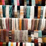 Rows of colorful woven textiles displayed at a market stall