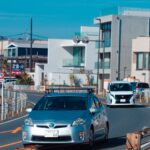Cars driving carefully on a narrow residential road in Japan