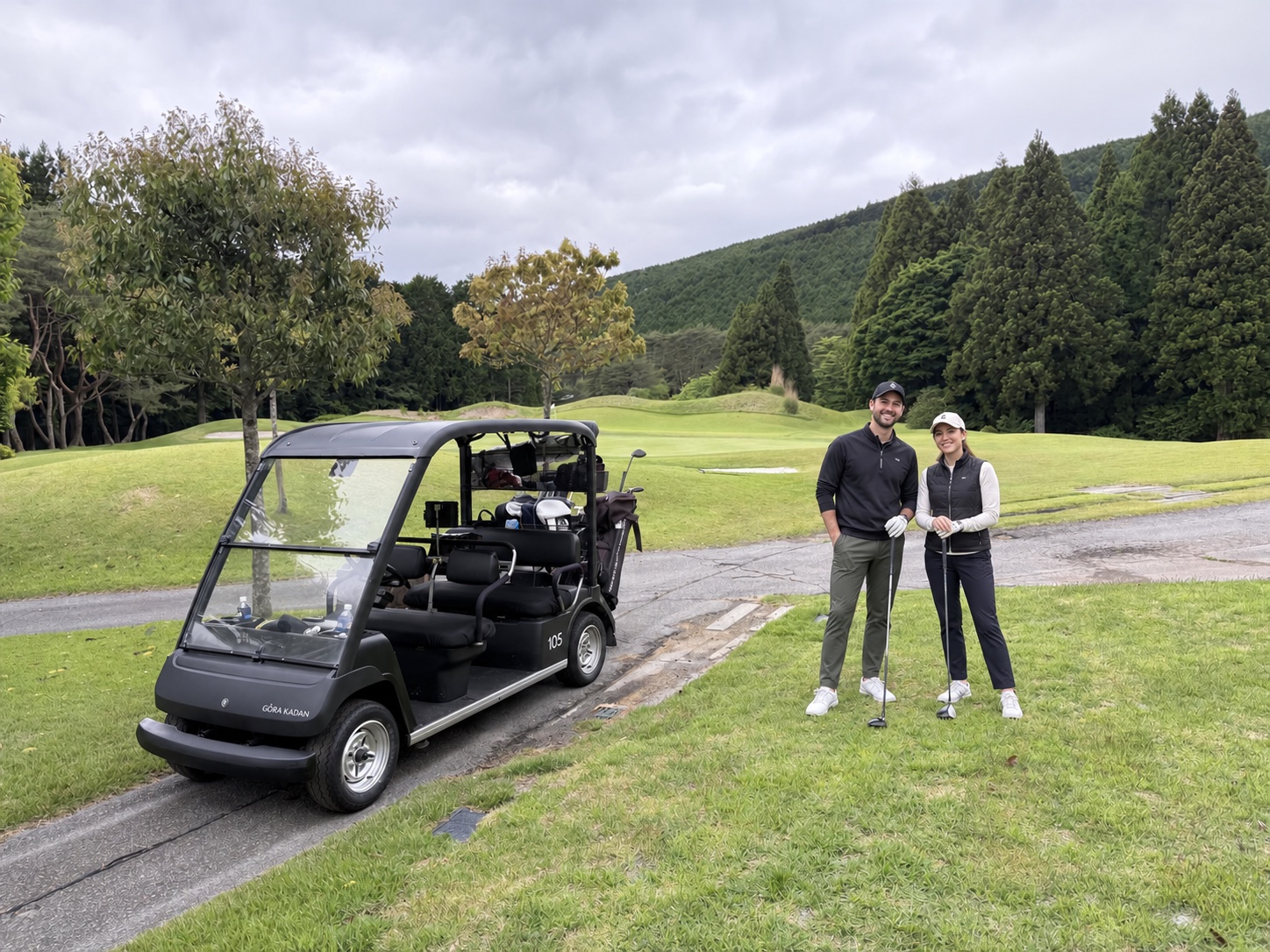 Two golfers standing beside a GORA KADAN cart on the course at GORA KADAN FUJI GOLF