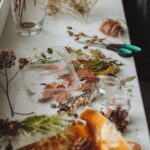 Dried flowers, twine, scissors and glass containers arranged for a botanical craft activity