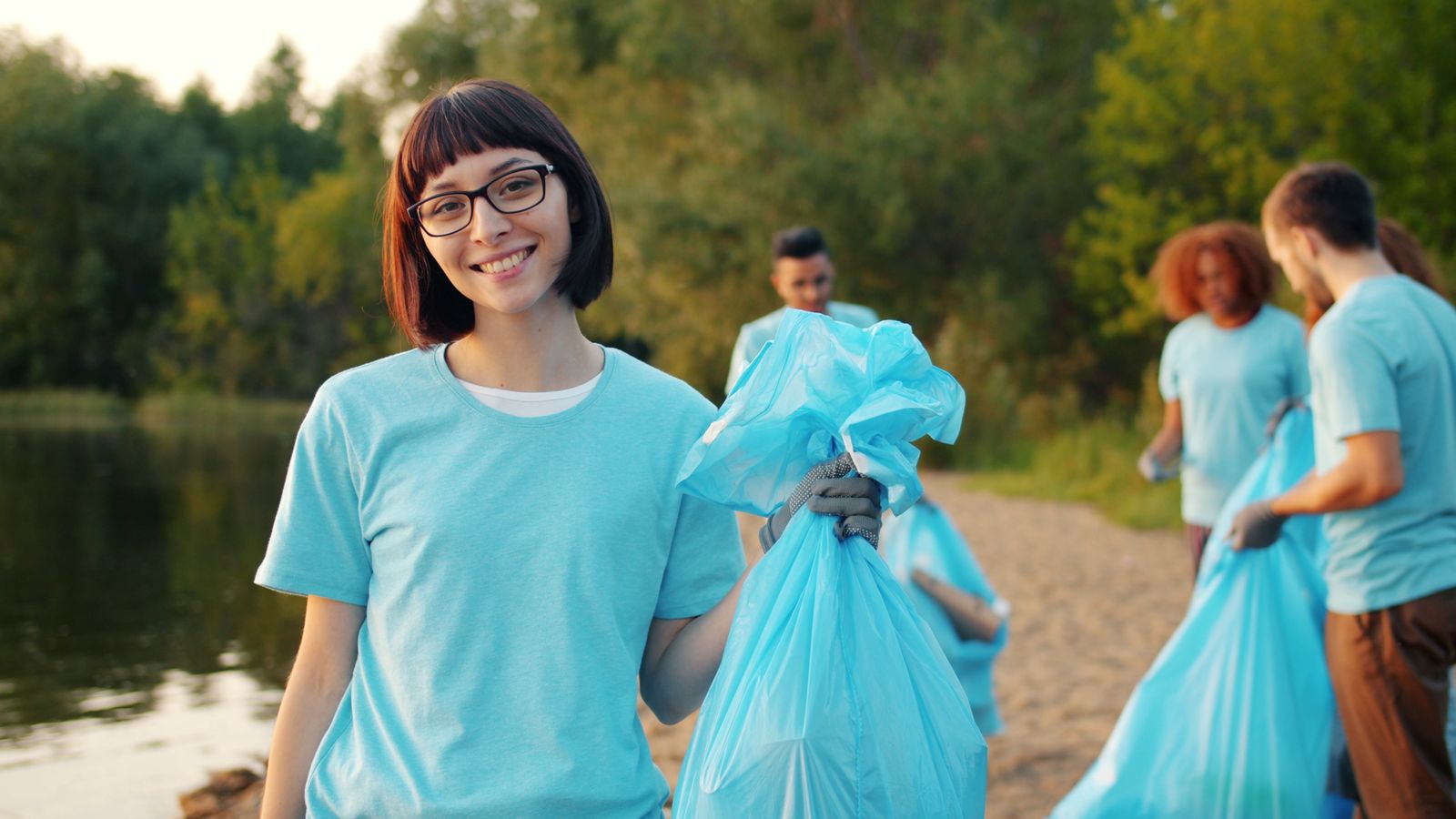 Volunteers collecting rubbish beside a river