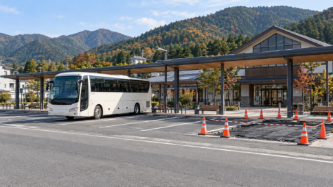 A tour coach beside a small coned-off parking work area at a Japanese station
