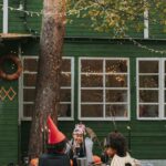 Children in Halloween costumes gathering outdoors with pumpkins and autumn decorations