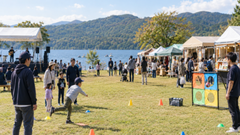 Families enjoying a ball game, stage, and market stalls beside Lake Yamanaka