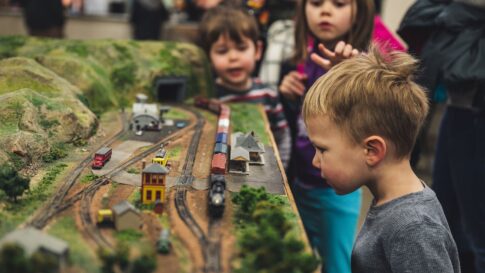 Children examining a detailed model railway display