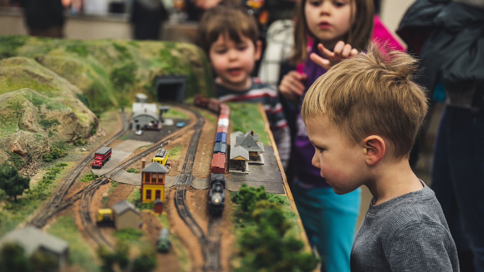 Children examining a detailed model railway display